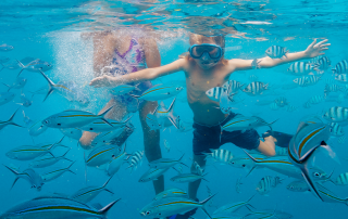 Two children snorkelling in clear water