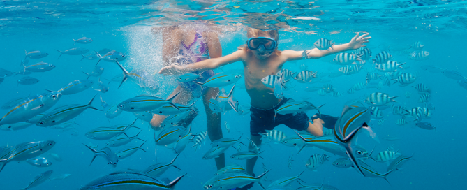 Two children snorkelling in clear water