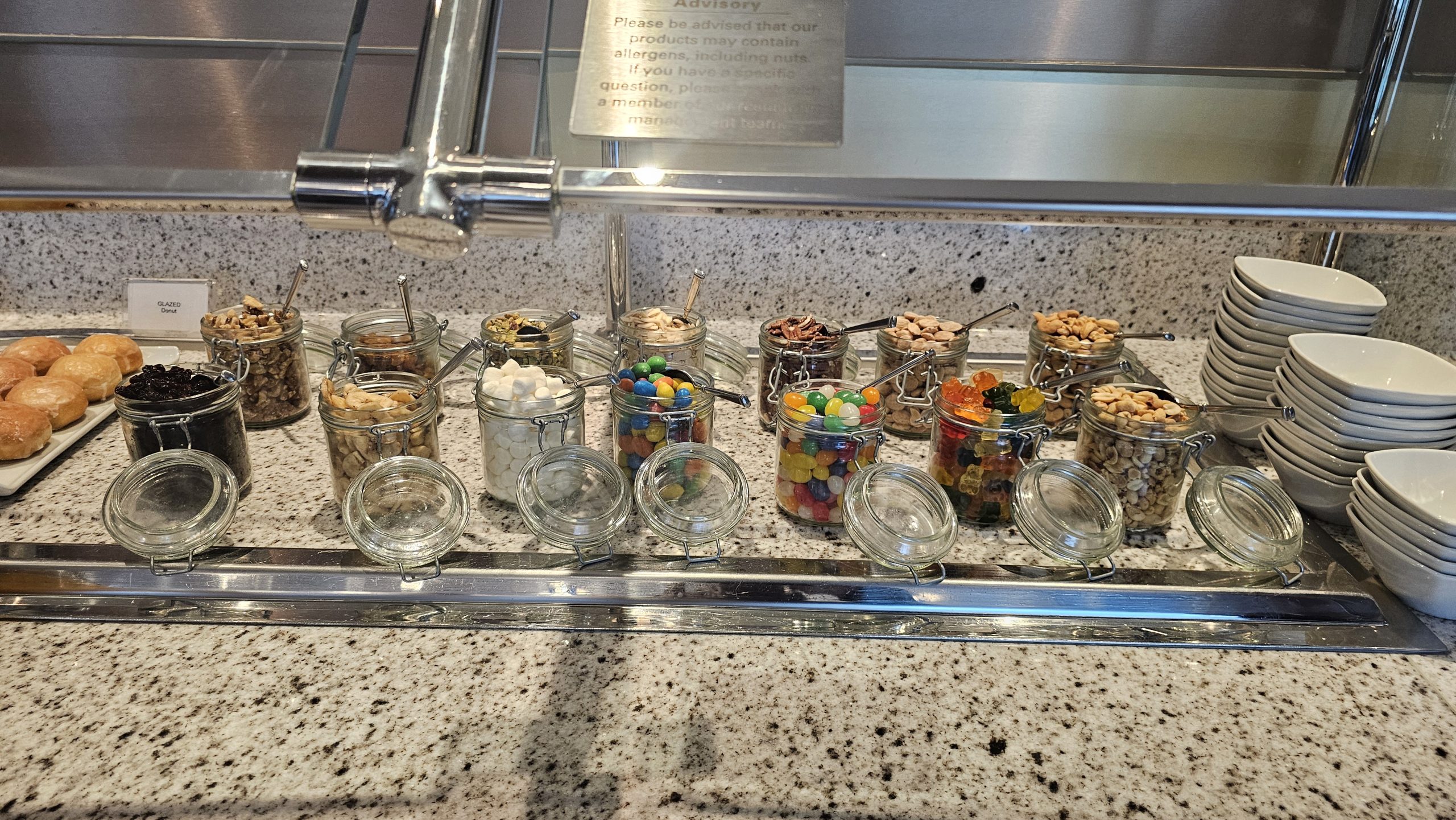 Dessert Buffet Cruise ship dessert bar featuring glass jars filled with sweets and toppings.