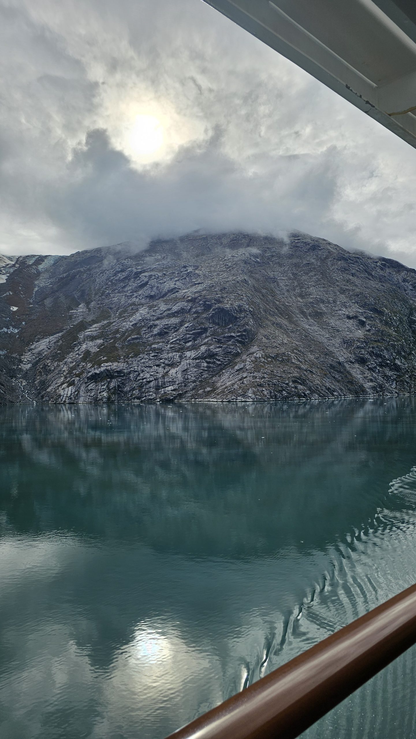 Glacier Bay, Alaska Glacier Bay, Alaska — calm turquoise waters and rugged cliffs viewed from an ocean cruise balcony.
