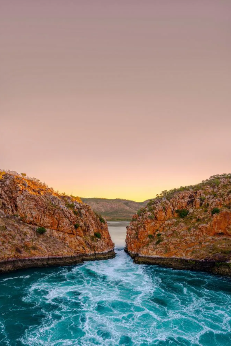 Horizontal Falls The Kimberley Coast in Western Australia at sunset, with turquoise waters and rugged red cliffs.