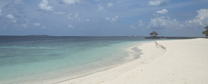 White sand beach and turquoise water in the Maldives, showing the calm, understated luxury of island resorts