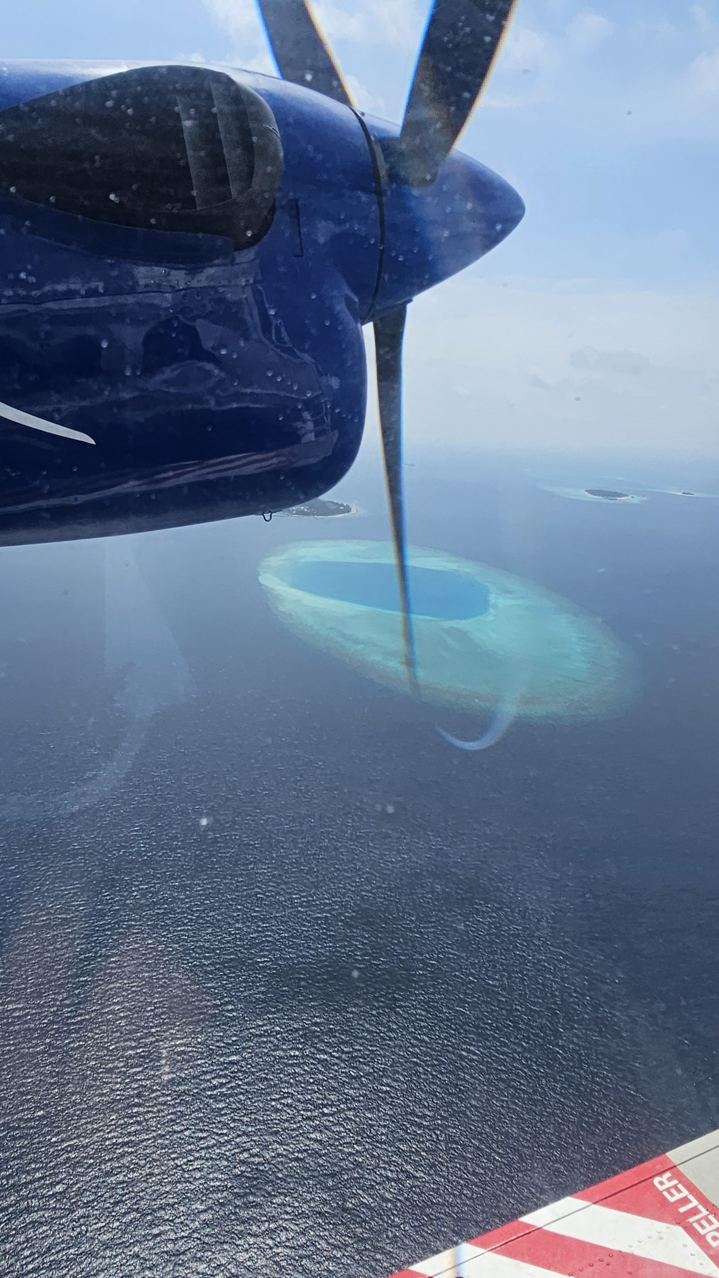 Aerial view of a Maldives atoll from a seaplane window