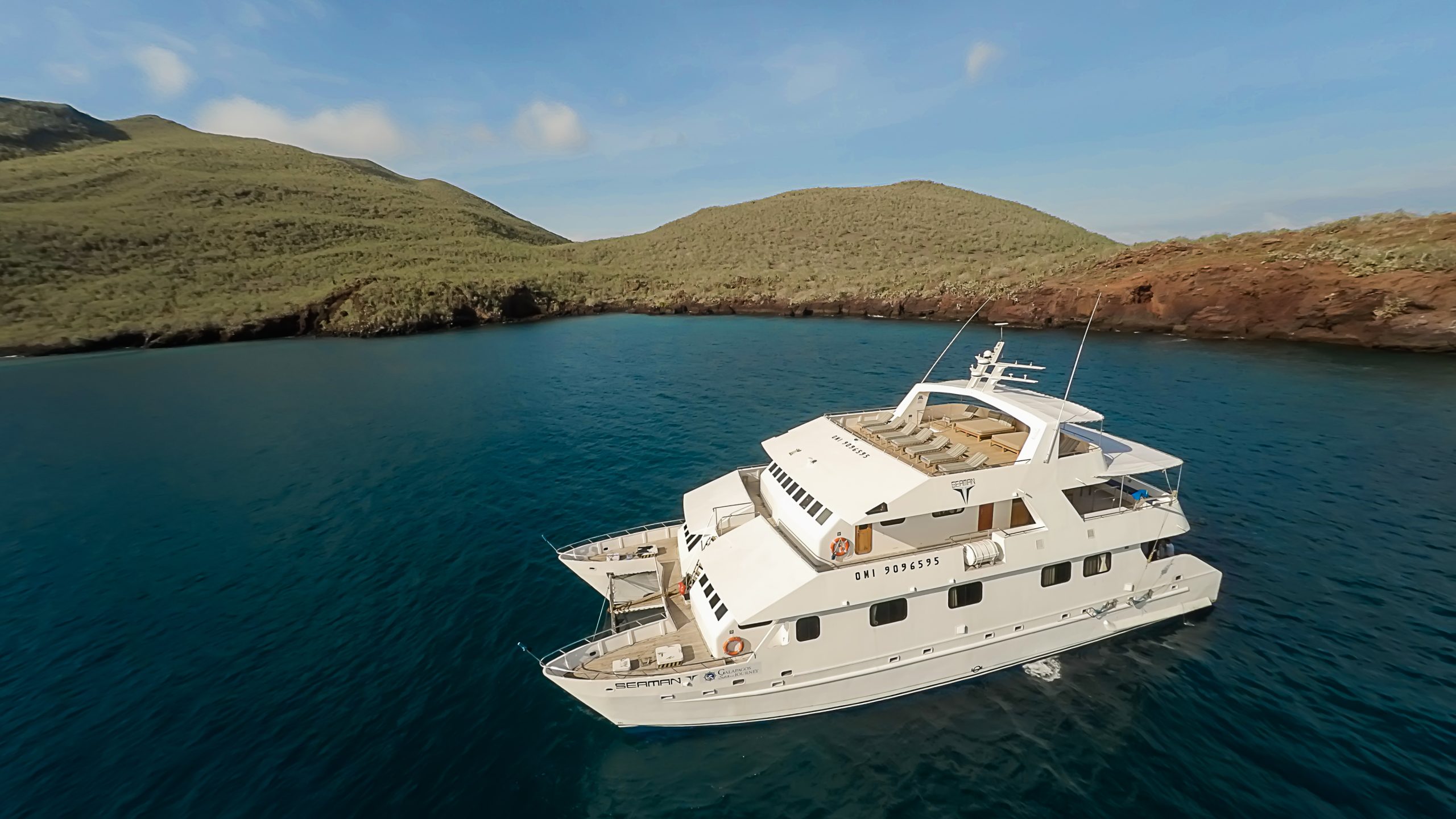 Small expedition yacht sailing between islands in the Galápagos.