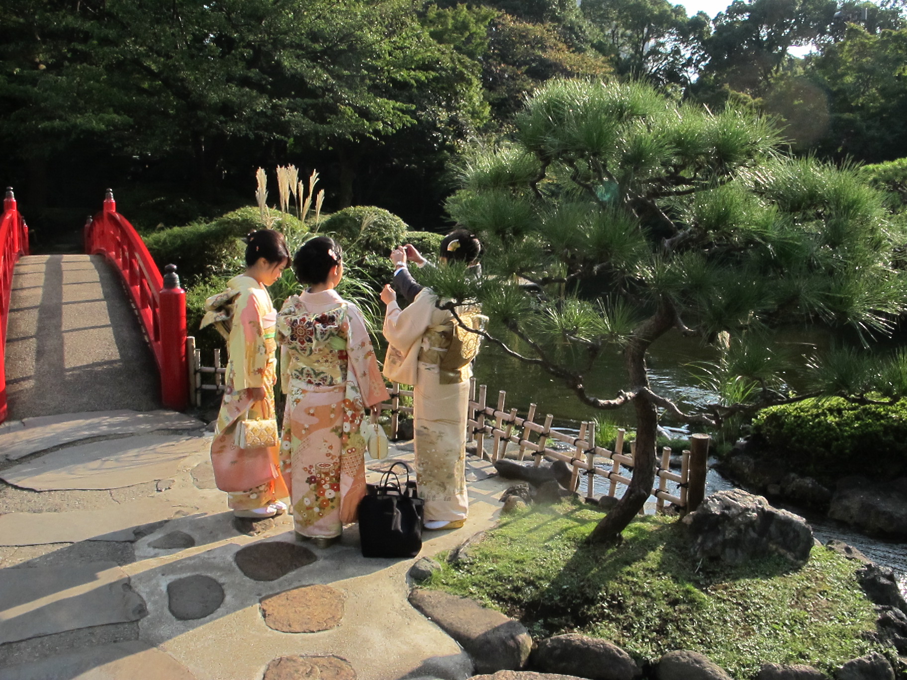 Travellers in kimono walking through a traditional Japanese garden in Tokyo