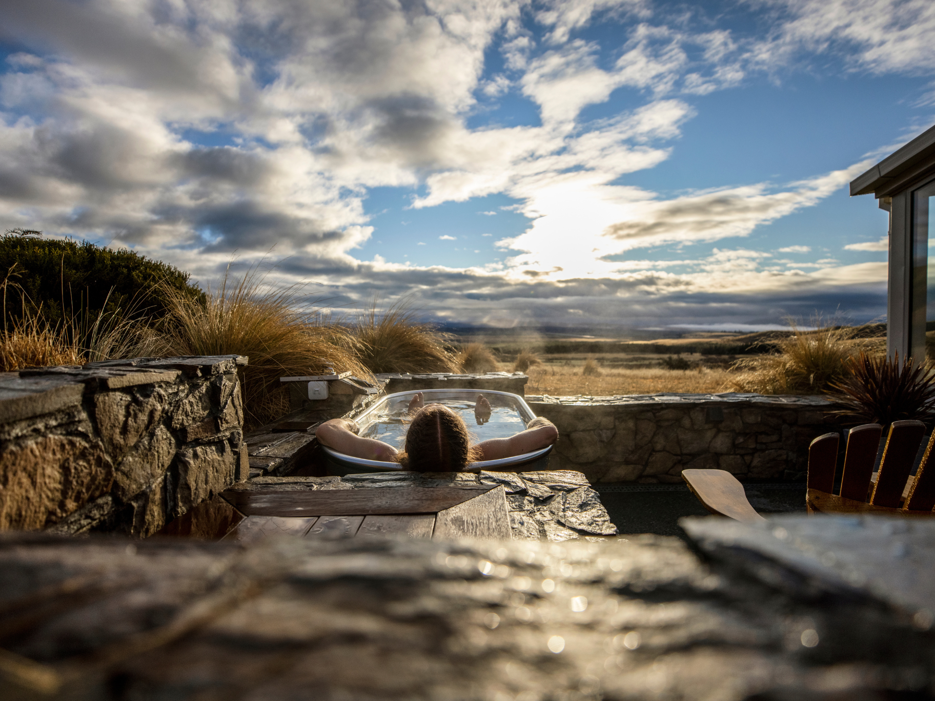 Outdoor hot tub with New Zealand landscape views Outdoor hot tub overlooking open landscape in New Zealand at sunset