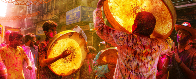 Festival drummers performing in a crowded street celebration surrounded by colour, music and energy