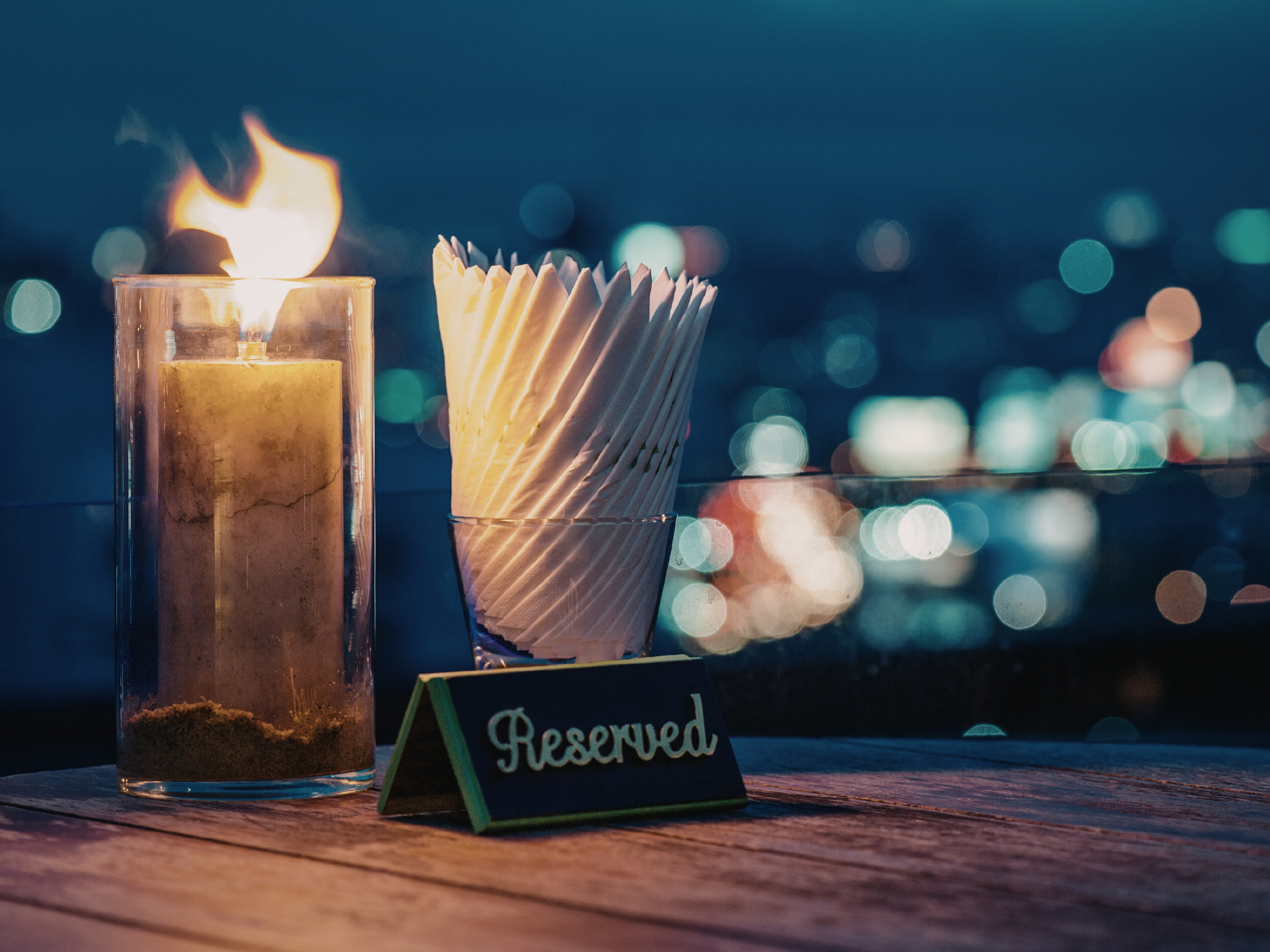 Choosing The Right Kind Of Energy Atmospheric rooftop table with candlelight overlooking glowing city lights at night